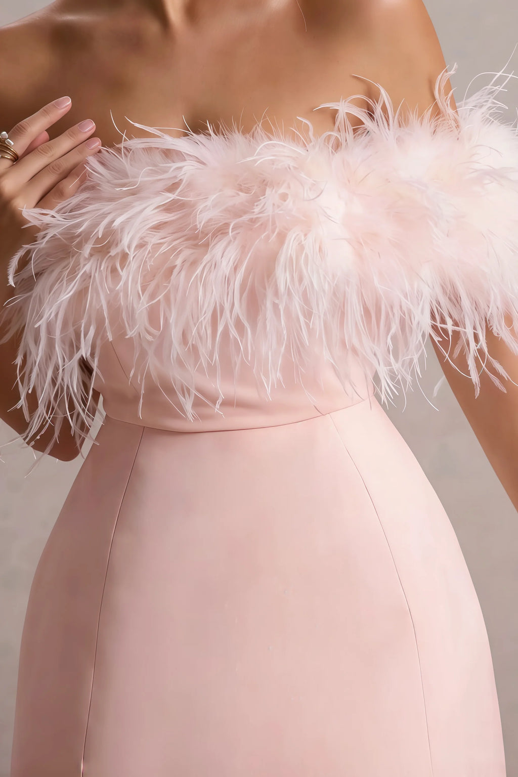 Macro shot of Chloe light pink dress feather trim, highlighting soft texture and craftsmanship on strapless bodice.