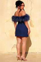 Back view of the Chloe navy blue crepe dress on a plus size model, featuring delicate feather trim, suitable for formal dinners.