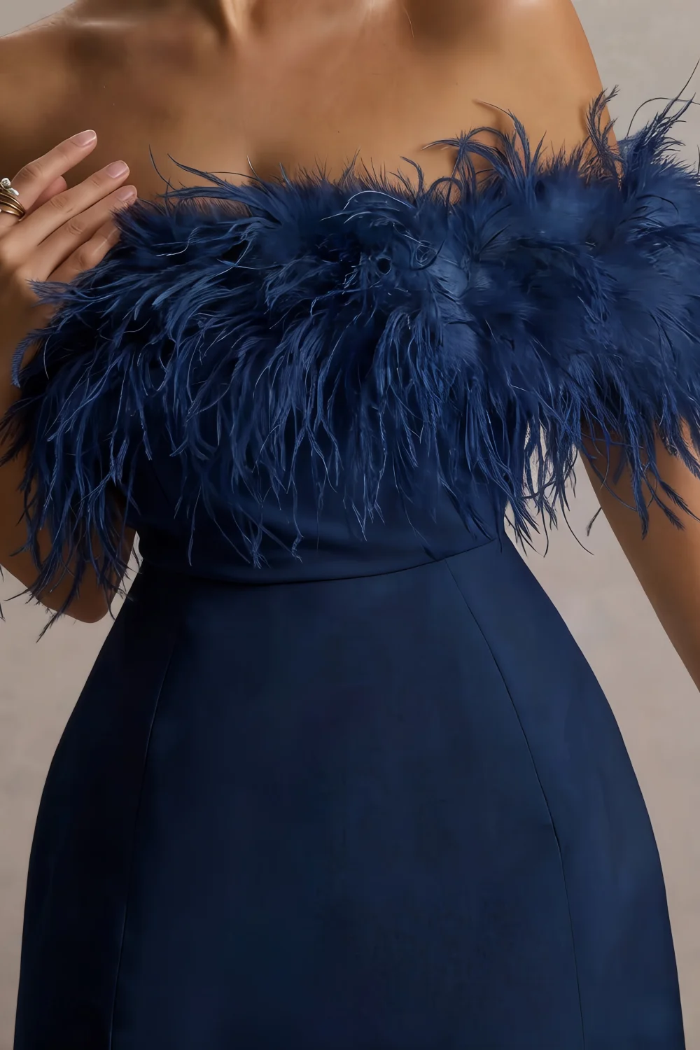 Close-up macro shot of the luxe dark navy feather trim and smooth crepe texture on the Chloe strapless cocktail dress.