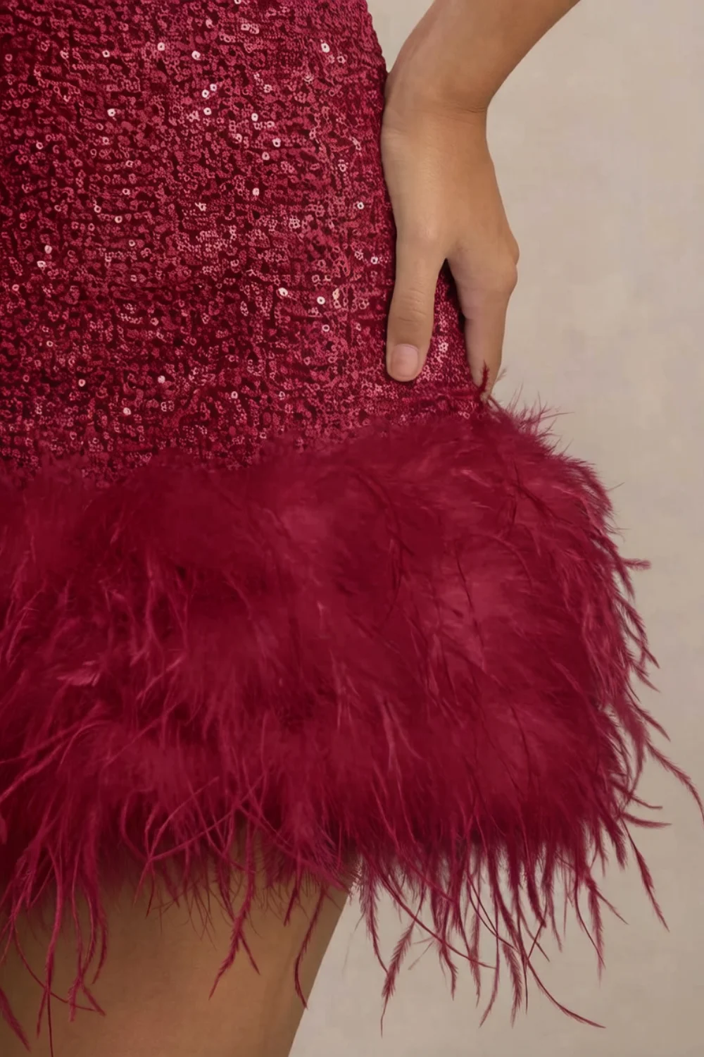 Detailed close up of burgundy feather trim on Christine sequin mini dress, showcasing texture and craftsmanship for luxury party wear.