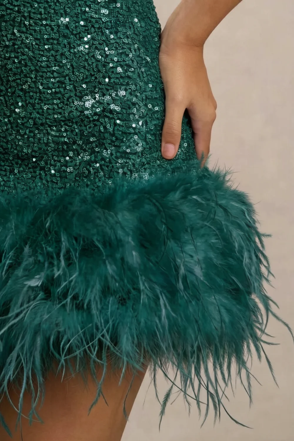 Macro close-up of Christine dress feather trim and sequin fabric texture, showcasing quality material and craftsmanship for luxury party wear.