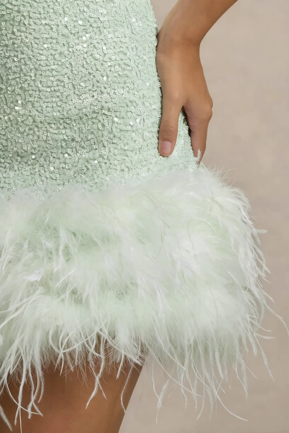 Close-up detail of Christine mint sequin dress feather trim, showcasing texture and craftsmanship of the hem.