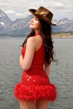 Customer in Christine red sequin dress with feather hem, standing by lake and mountain, stylish travel or event look, sleeveless high neck design