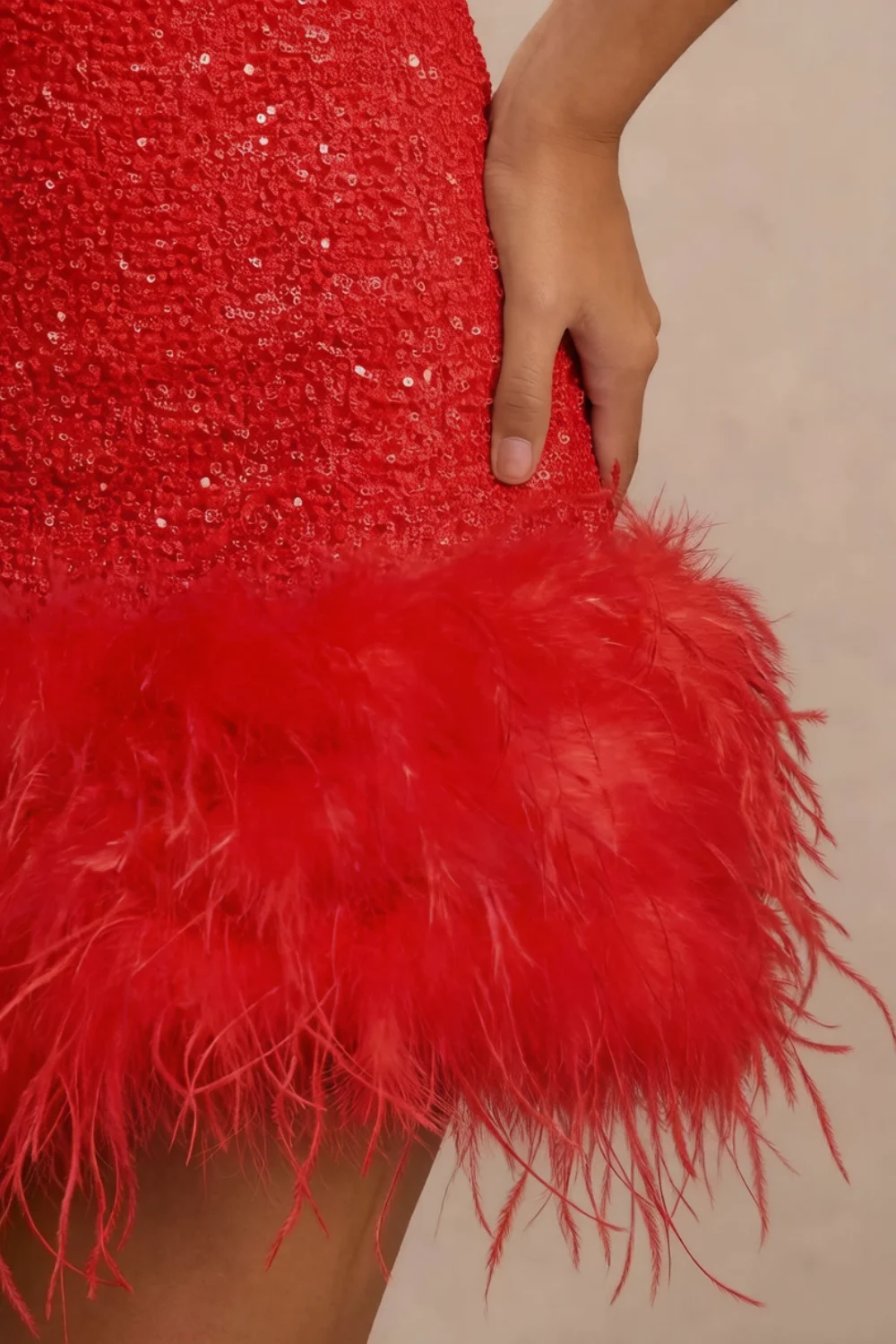 Christine red sequin dress feather trim close-up, detailed texture of feather hem and sequin fabric, luxury design element