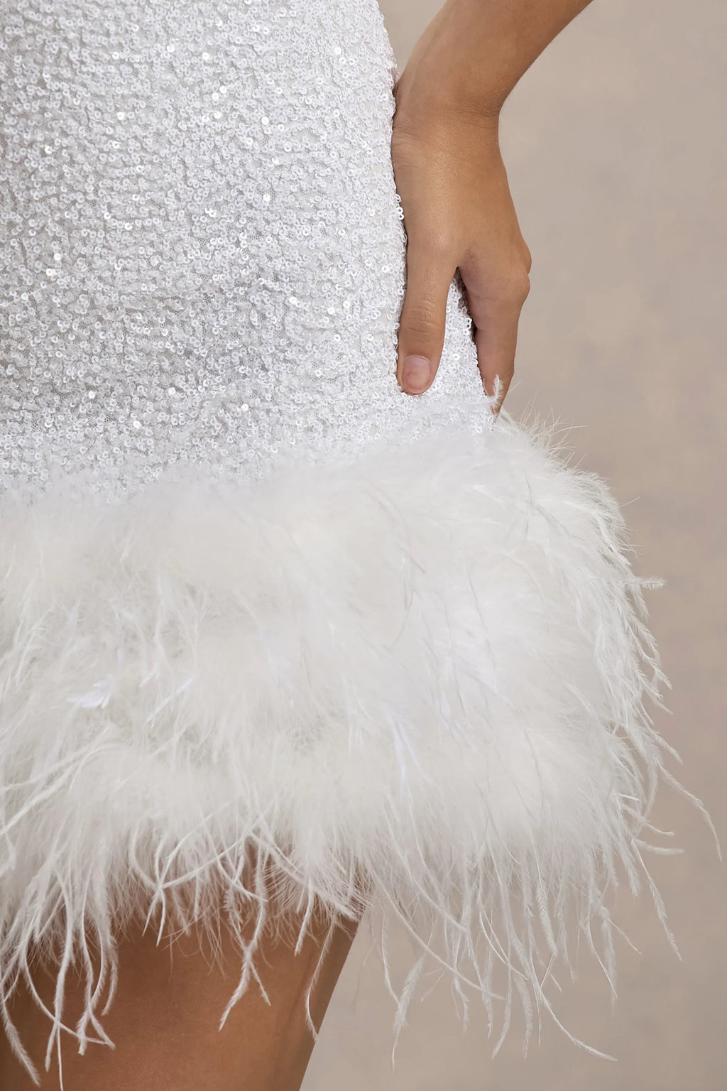 Detailed close-up of Christine white sequin fabric texture and soft feather trim, showcasing the quality of the party dress material.