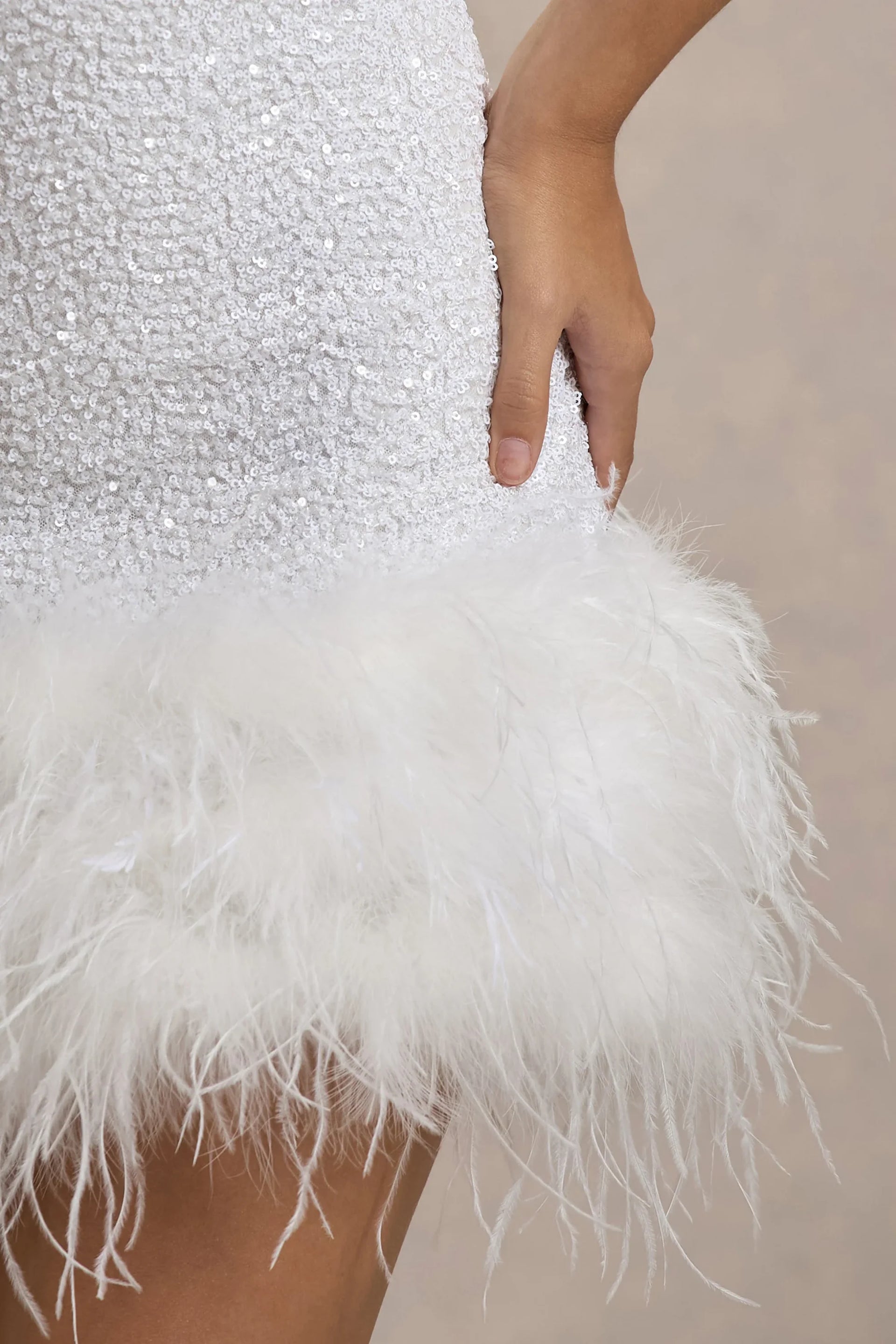 Detailed close-up of Christine white sequin fabric texture and soft feather trim, showcasing the quality of the party dress material.