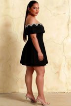 Side angle of plus size Christy black mini dress demonstrating the comfortable fit and flowy A-line skirt.