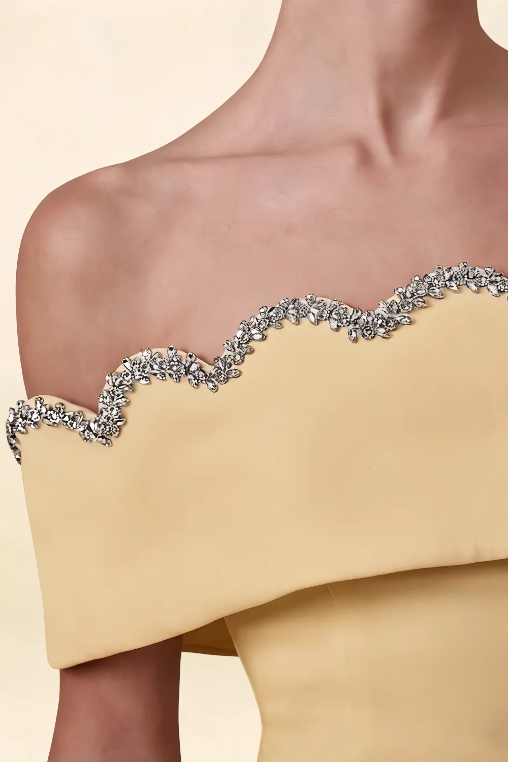 Extreme close-up of Christy dress rhinestone波浪 trim, silver glitter detail on yellow crepe off-shoulder neckline.