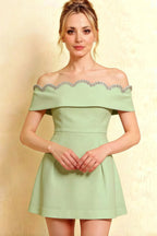 Close-up front view of Christy mint off the shoulder dress highlighting the intricate silver rhinestone wave trim on the neckline.