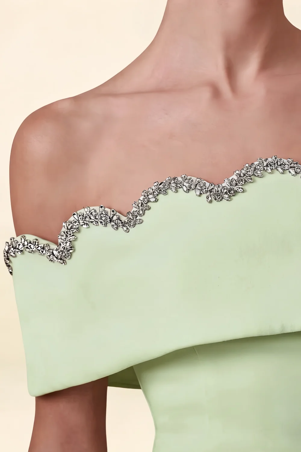 Macro close-up detail of the silver rhinestone scallop trim on the Christy mint off the shoulder dress, set against smooth crepe fabric.