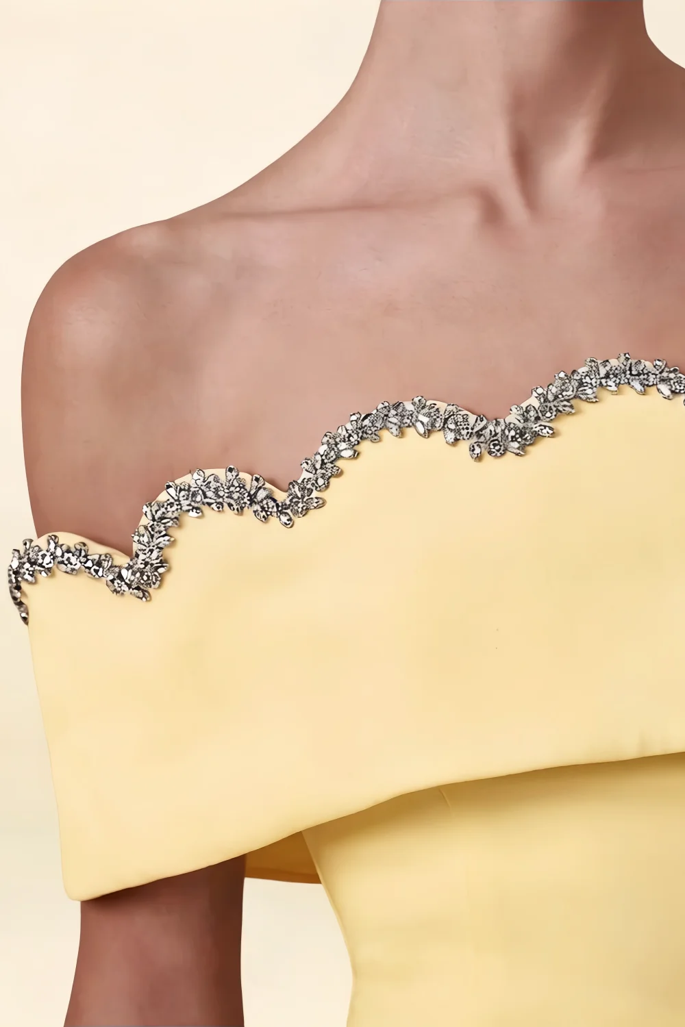 Macro close up detail of the Christy pastel yellow dress showcasing the silver rhinestone embellished scalloped edge.