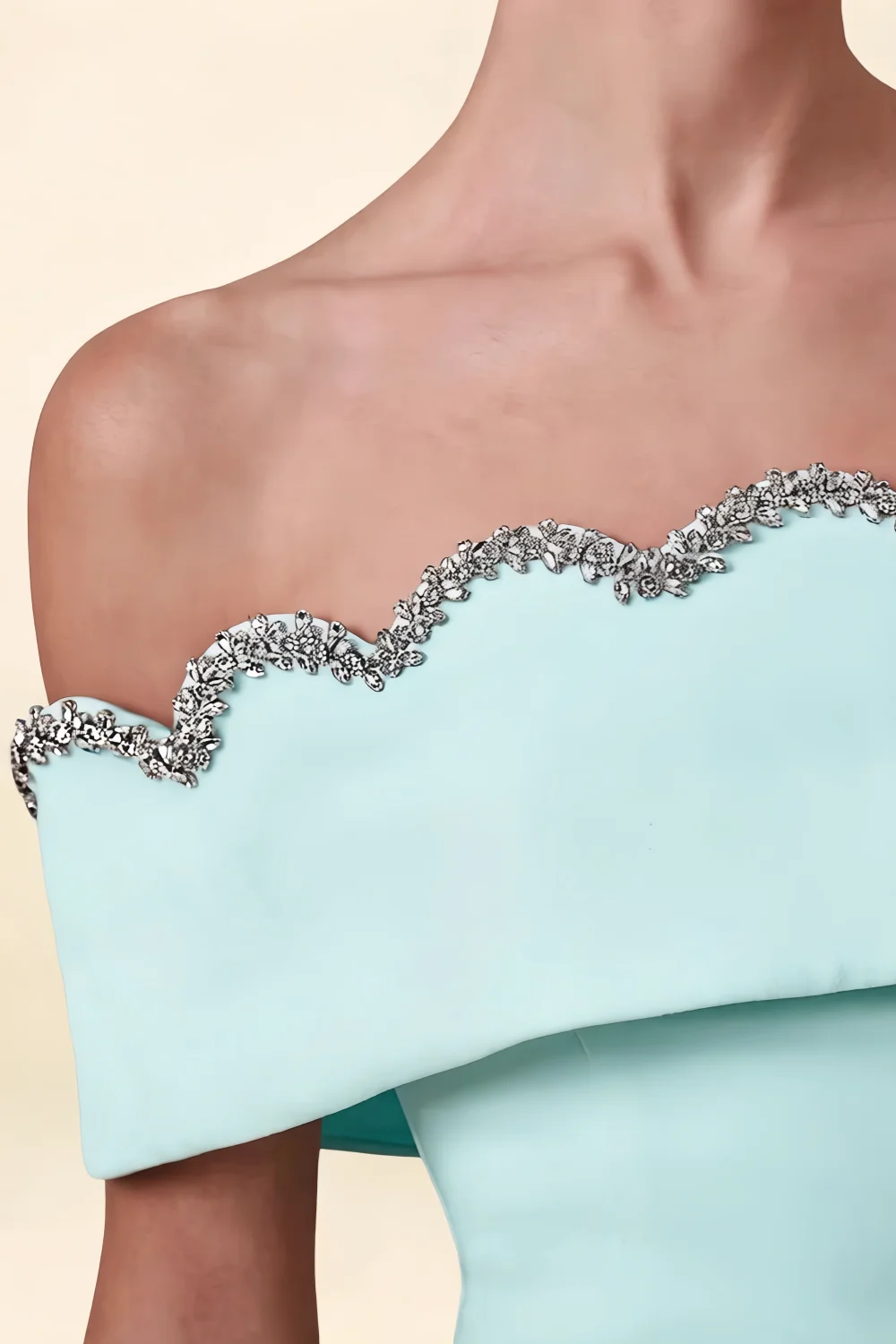 Extreme close-up macro shot of the Christy dress detailing, focusing on the intricate silver beaded trim along the off-shoulder wave edge.