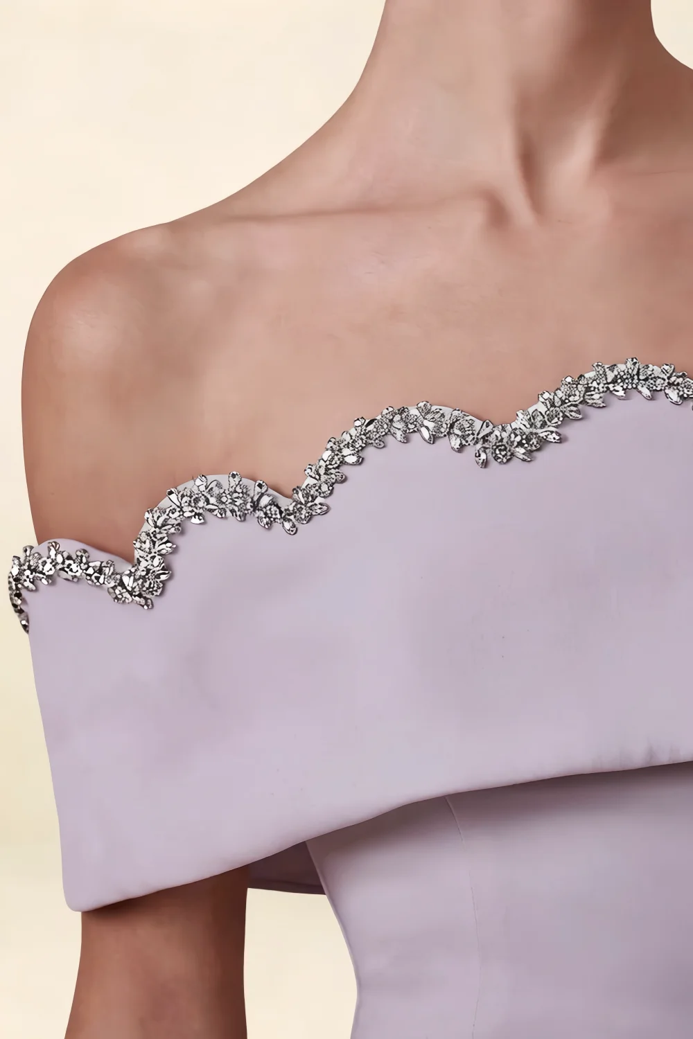 Extreme close-up detail of the Christy dress showcasing intricate silver rhinestone wave applique on the off-shoulder neckline.
