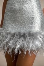 Close up detail of silver sequins and soft grey feather trim on Cindy mini dress hem.