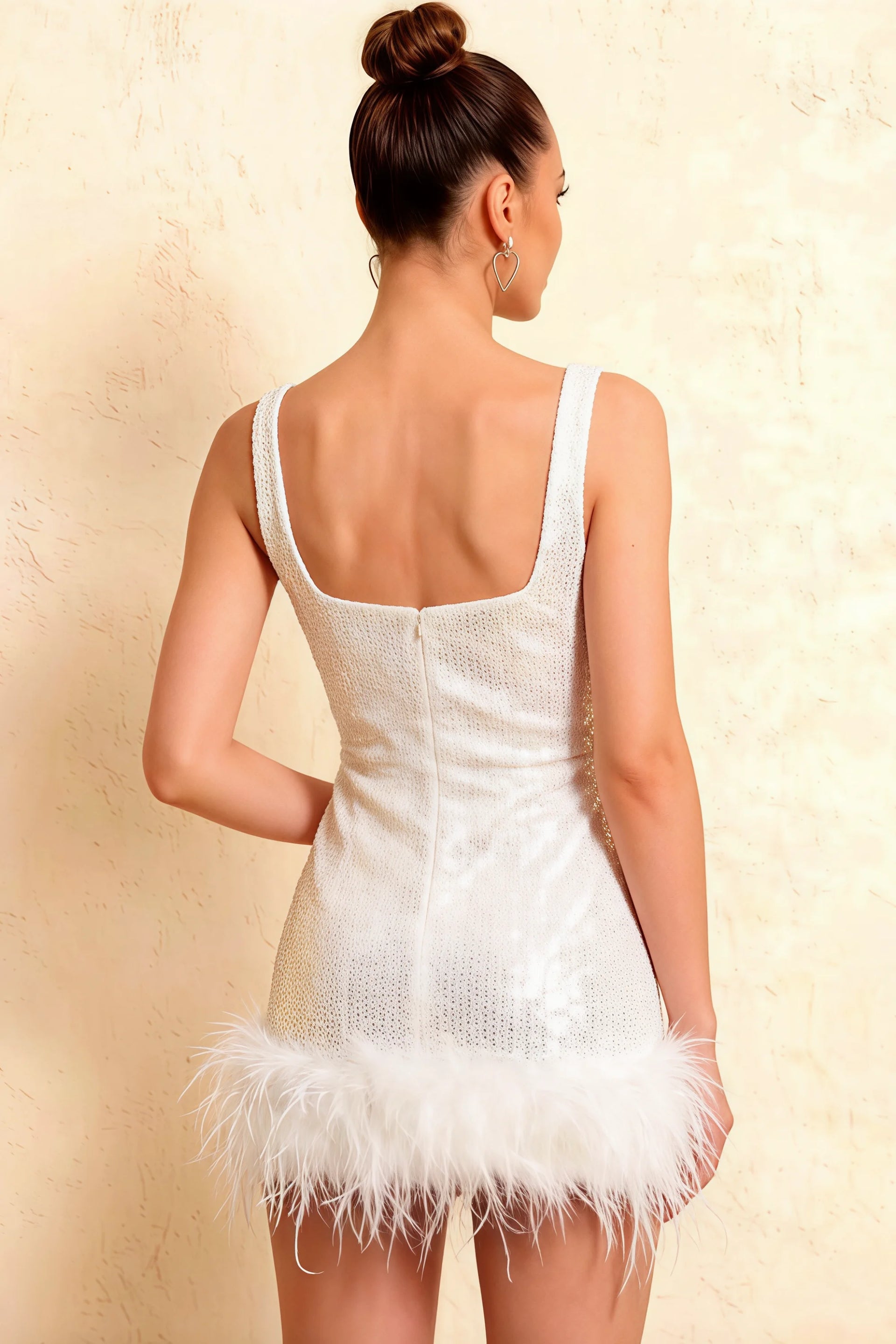 Detailed back view of Cindy white sequin dress, focusing on the open back and feather hem detail, semi-formal attire.