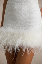 Close-up of Cindy white sequin dress feather trim and fabric texture, highlighting the quality and details of the material.