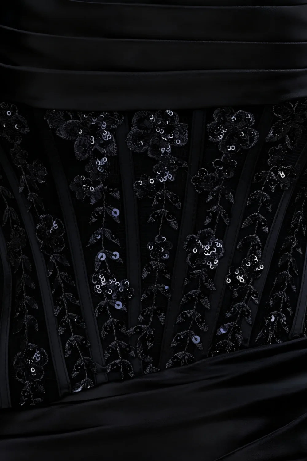 Extreme close-up detail of Clara dress bodice showcasing floral sequin lace applique over satin background fabric.