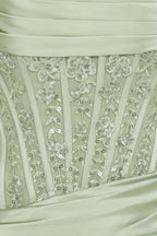 Close up of Clara dress bodice with intricate lace and sequin embellishment on sage green satin