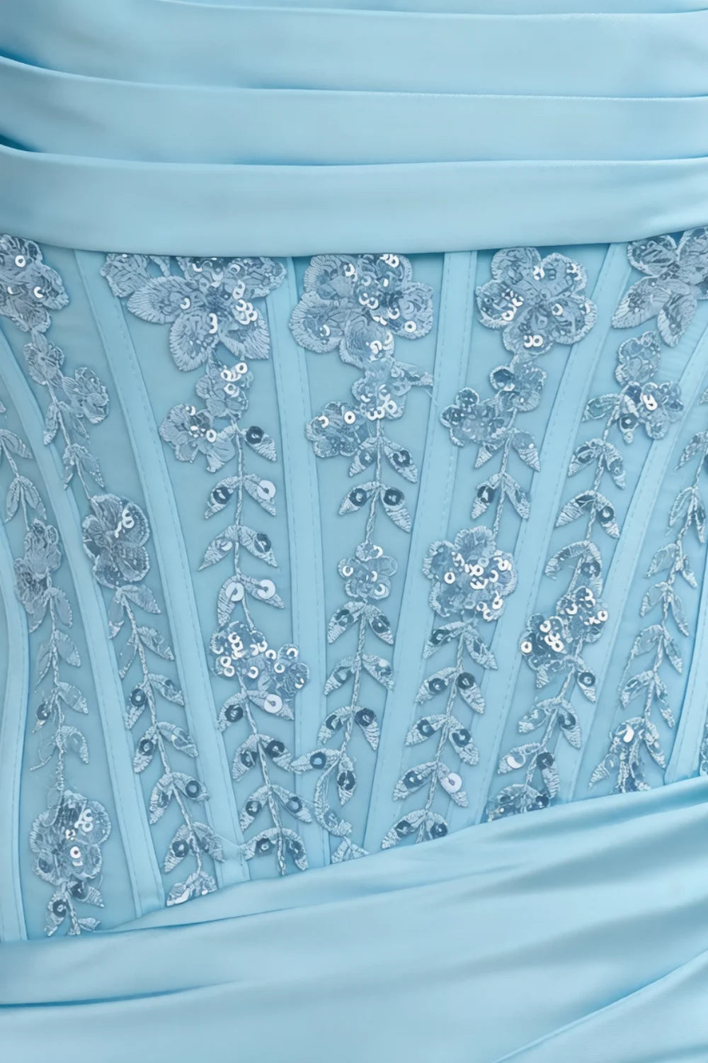 Macro close-up of Clara dress sky blue fabric with floral sequin lace and satin texture