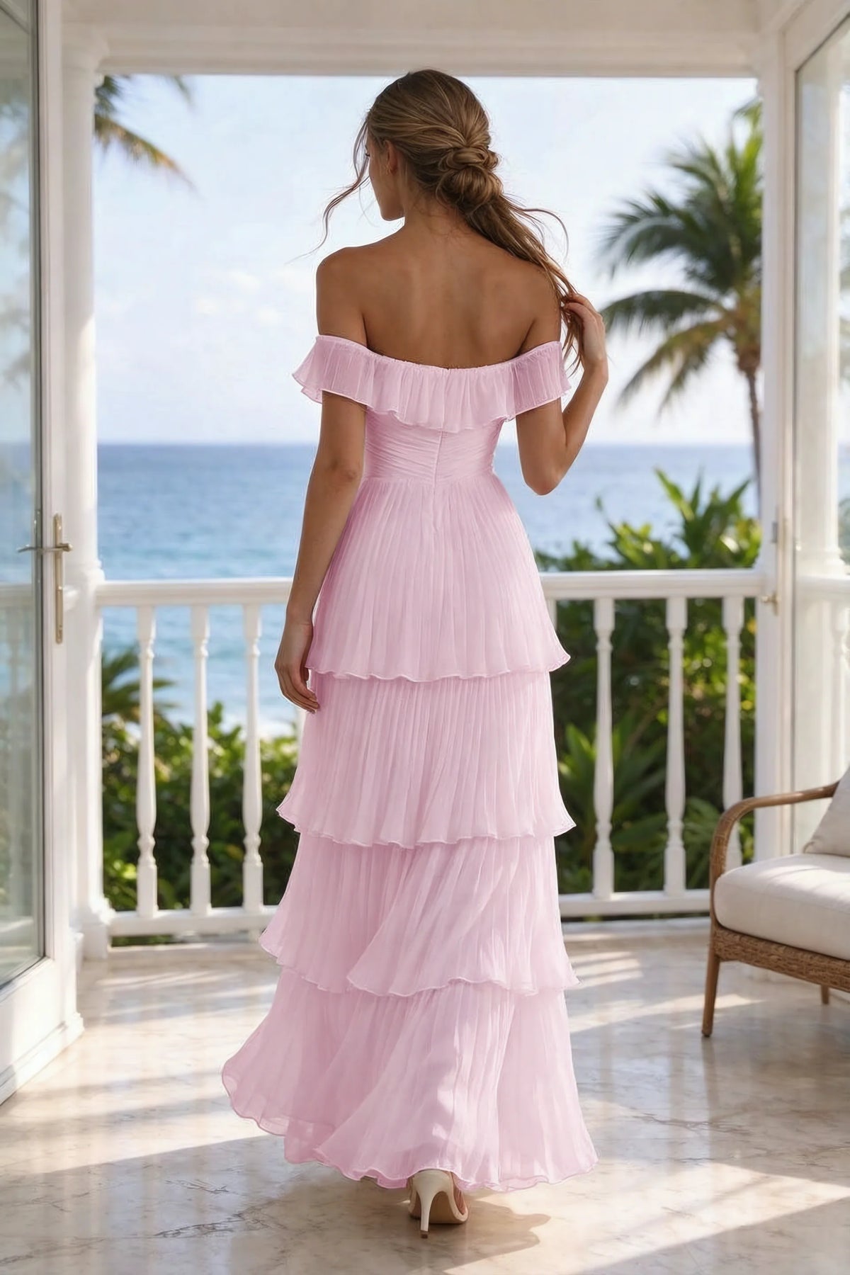 Outdoor rear view on a seaside terrace of Seraphina candy pink tiered ruffle maxi dress with a long flowing skirt