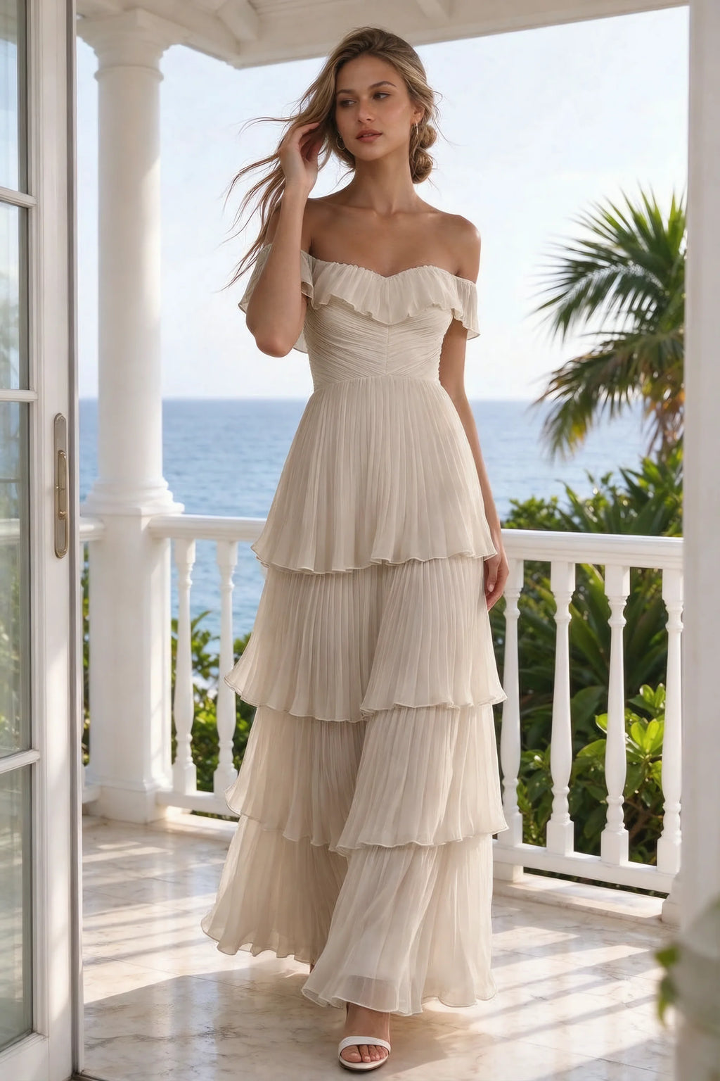 Outdoor front view on a seaside terrace of Seraphina cream tiered ruffle maxi dress with a long flowing skirt