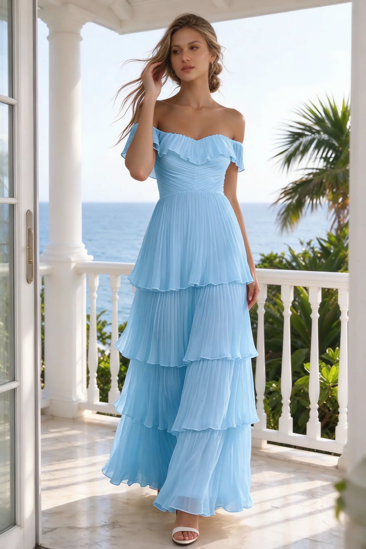 Outdoor front view on a seaside terrace of Seraphina haze blue tiered ruffle maxi dress with a long flowing skirt