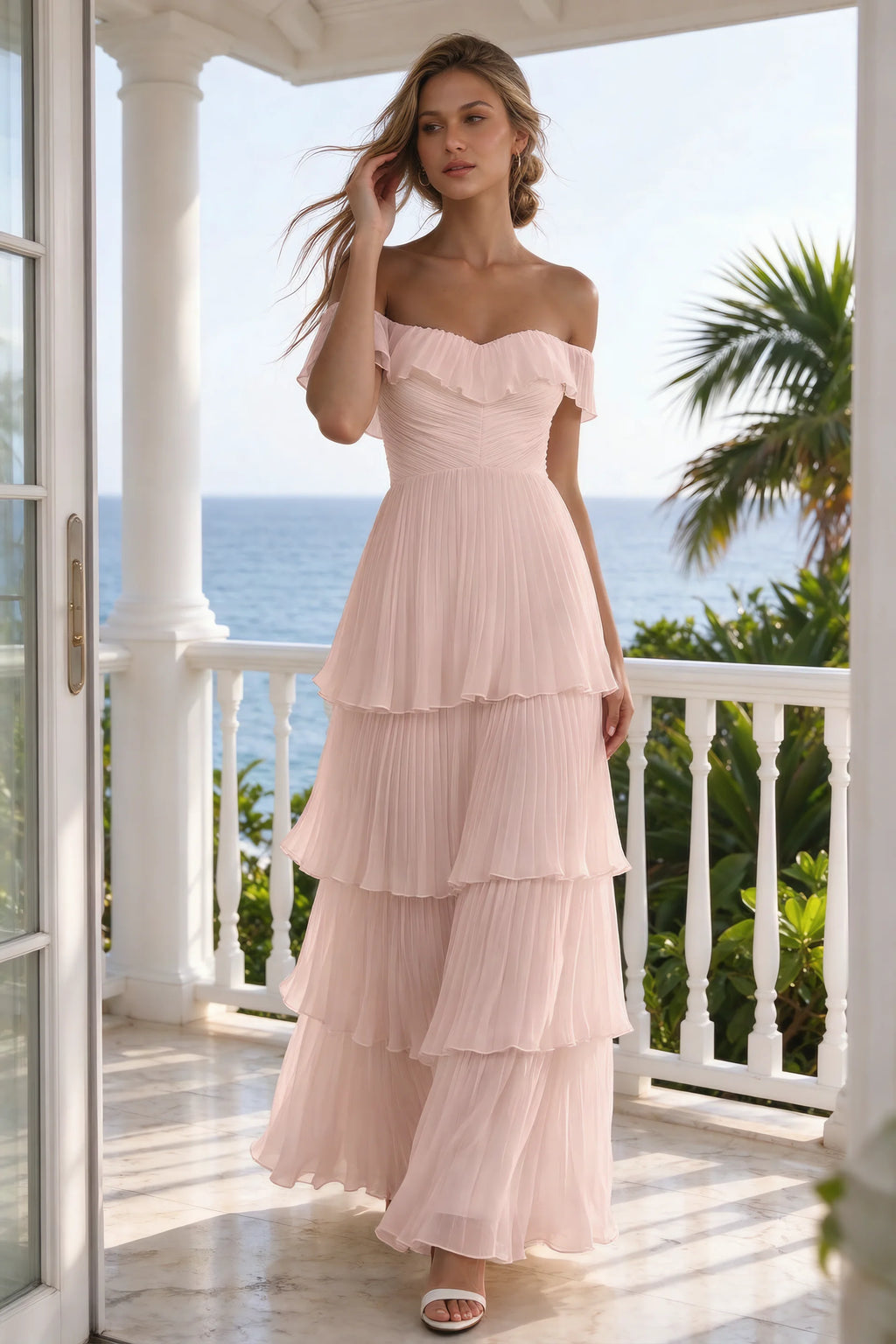Outdoor front view on a seaside terrace of Seraphina haze pink tiered ruffle maxi dress with a long flowing skirt