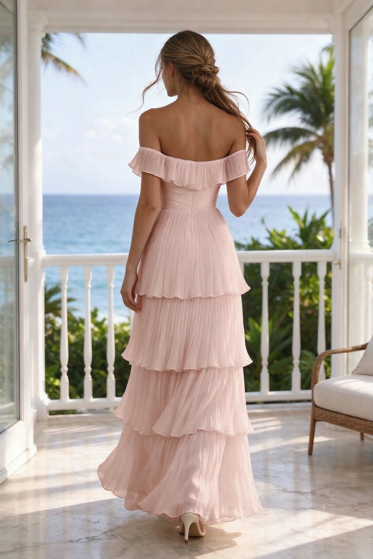 Outdoor rear view on a seaside terrace of Seraphina haze pink tiered ruffle maxi dress with a long flowing skirt