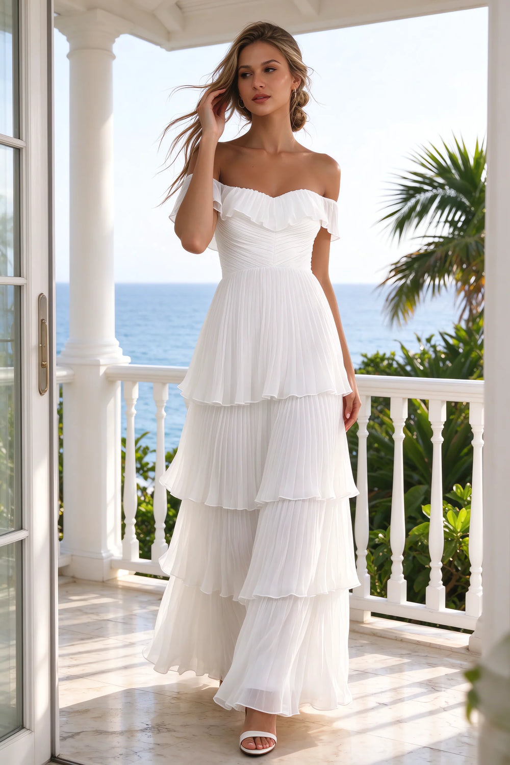 Translation missing: en.Outdoor front view on a seaside terrace of Seraphina white tiered ruffle maxi dress with a long flowing skirt content.product_image_secondary
