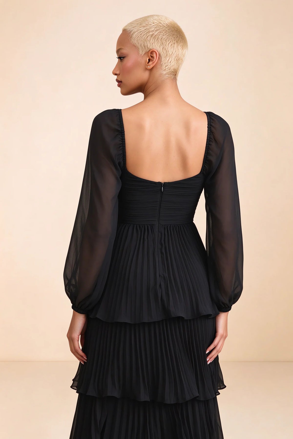 Close-up of low square back, sheer sleeves and centre-back zipper of Sienna black tiered pleated maxi dress