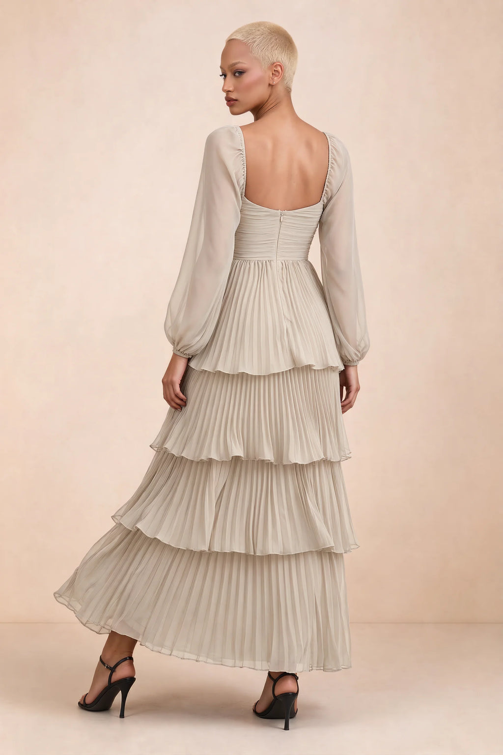 Rear studio view of Sienna cream tiered pleated maxi dress with a long flowing skirt