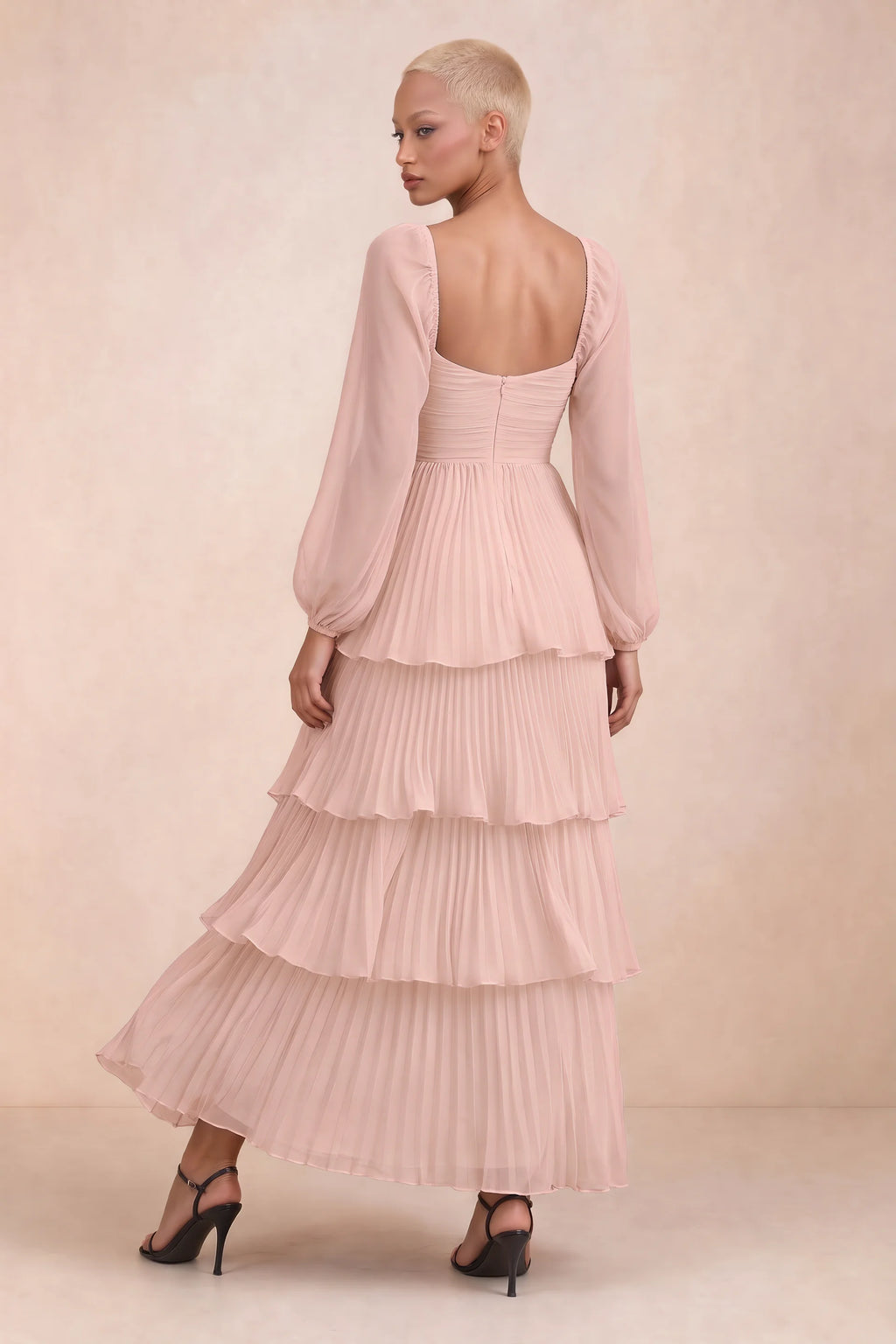 Rear studio view of Sienna haze pink tiered pleated maxi dress with a long flowing skirt