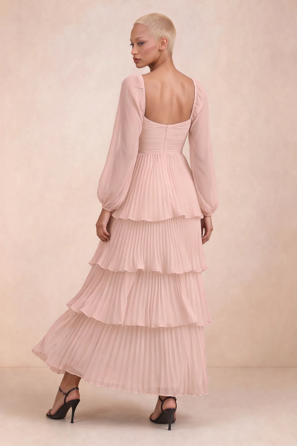 Rear studio view of Sienna haze pink tiered pleated maxi dress with a long flowing skirt