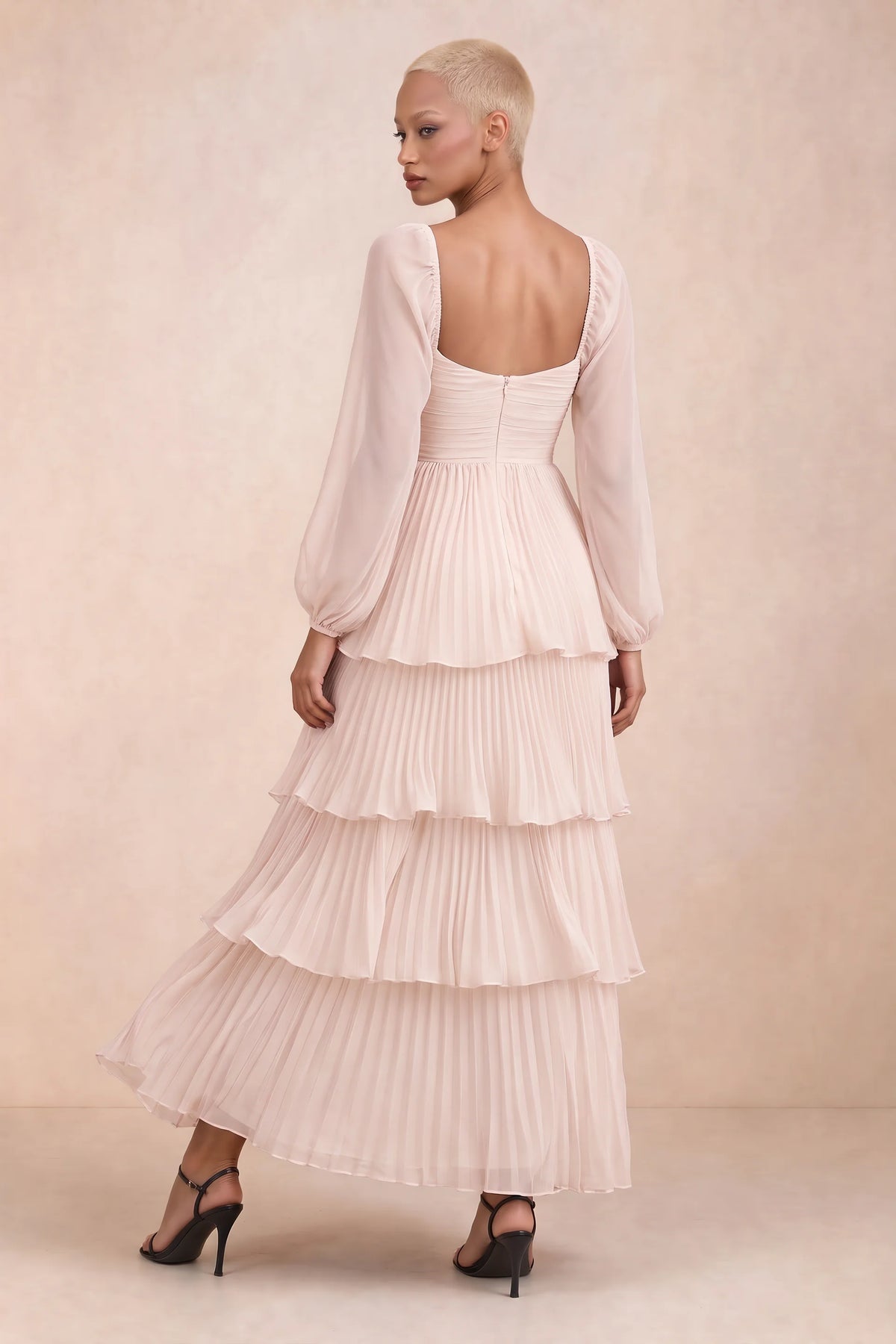 Rear studio view of Sienna powder pink tiered pleated maxi dress with a long flowing skirt