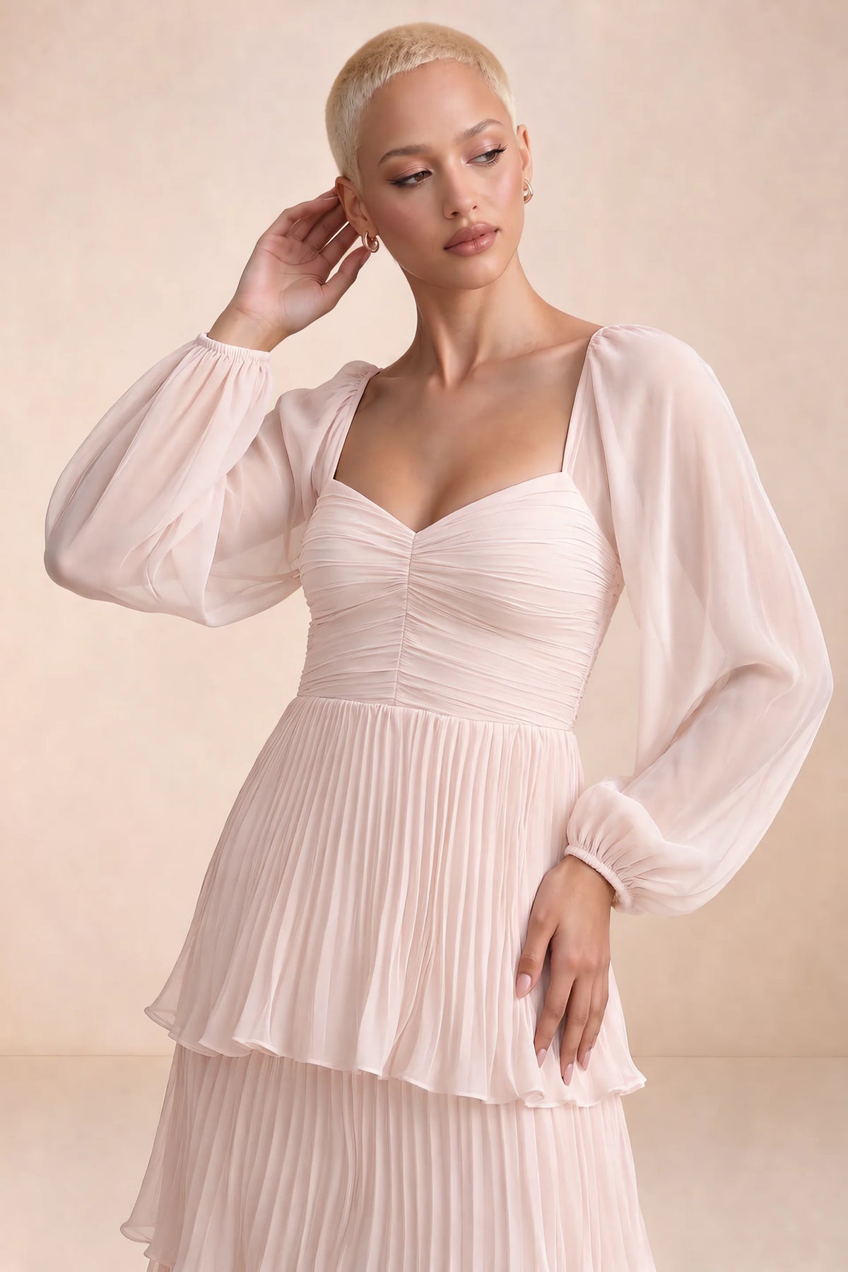 Close-up of sweetheart neckline, sheer sleeves and ruched waist of Sienna powder pink tiered pleated maxi dress