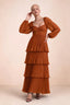 Front studio view of Sienna rust tiered pleated maxi dress with a long flowing skirt
