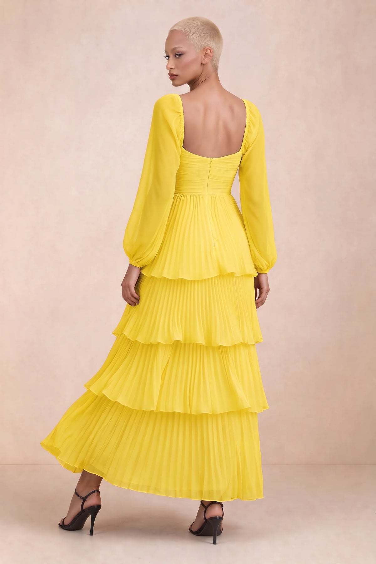 Rear studio view of Sienna yellow tiered pleated maxi dress with a long flowing skirt