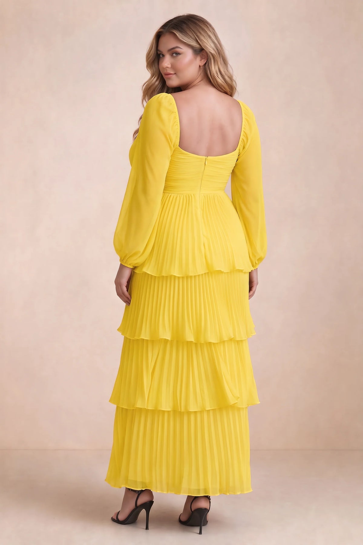 Rear view on a second model of Sienna yellow tiered pleated maxi dress with a long flowing skirt