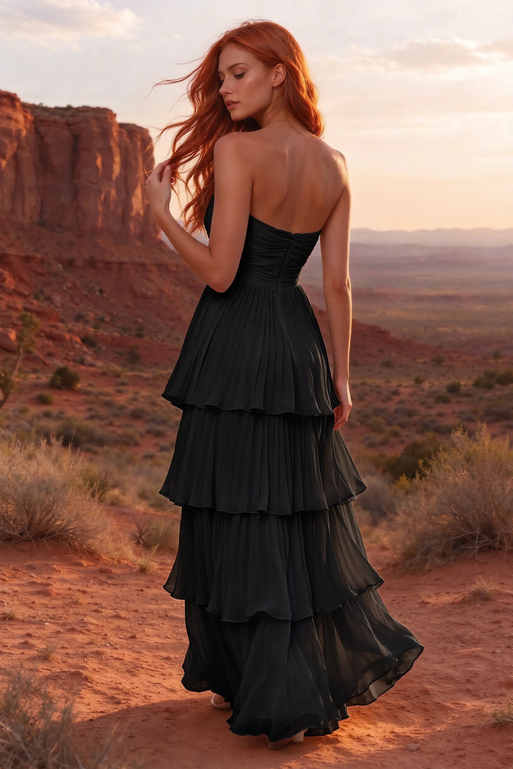 Outdoor rear view in a desert canyon at sunset of Sonia black tiered pleated maxi dress with a long flowing skirt