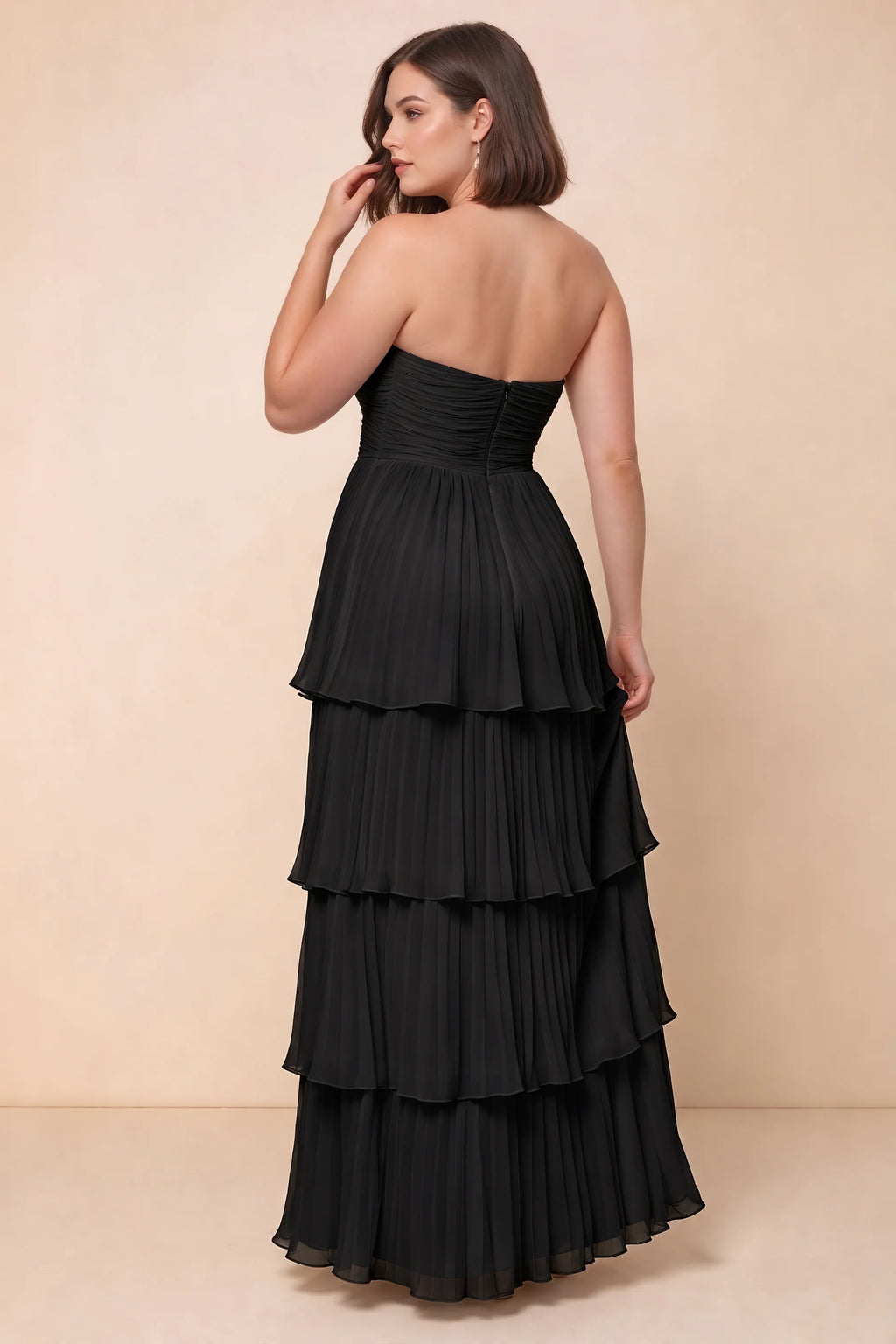 Rear view on a second model of Sonia black tiered pleated maxi dress with a long flowing skirt