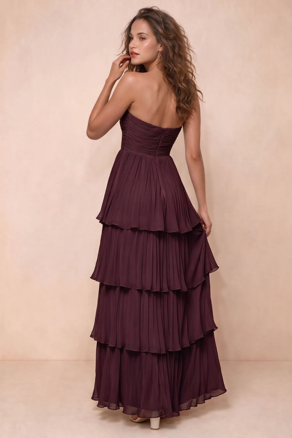 Rear studio view of Sonia burgundy tiered pleated maxi dress with a long flowing skirt
