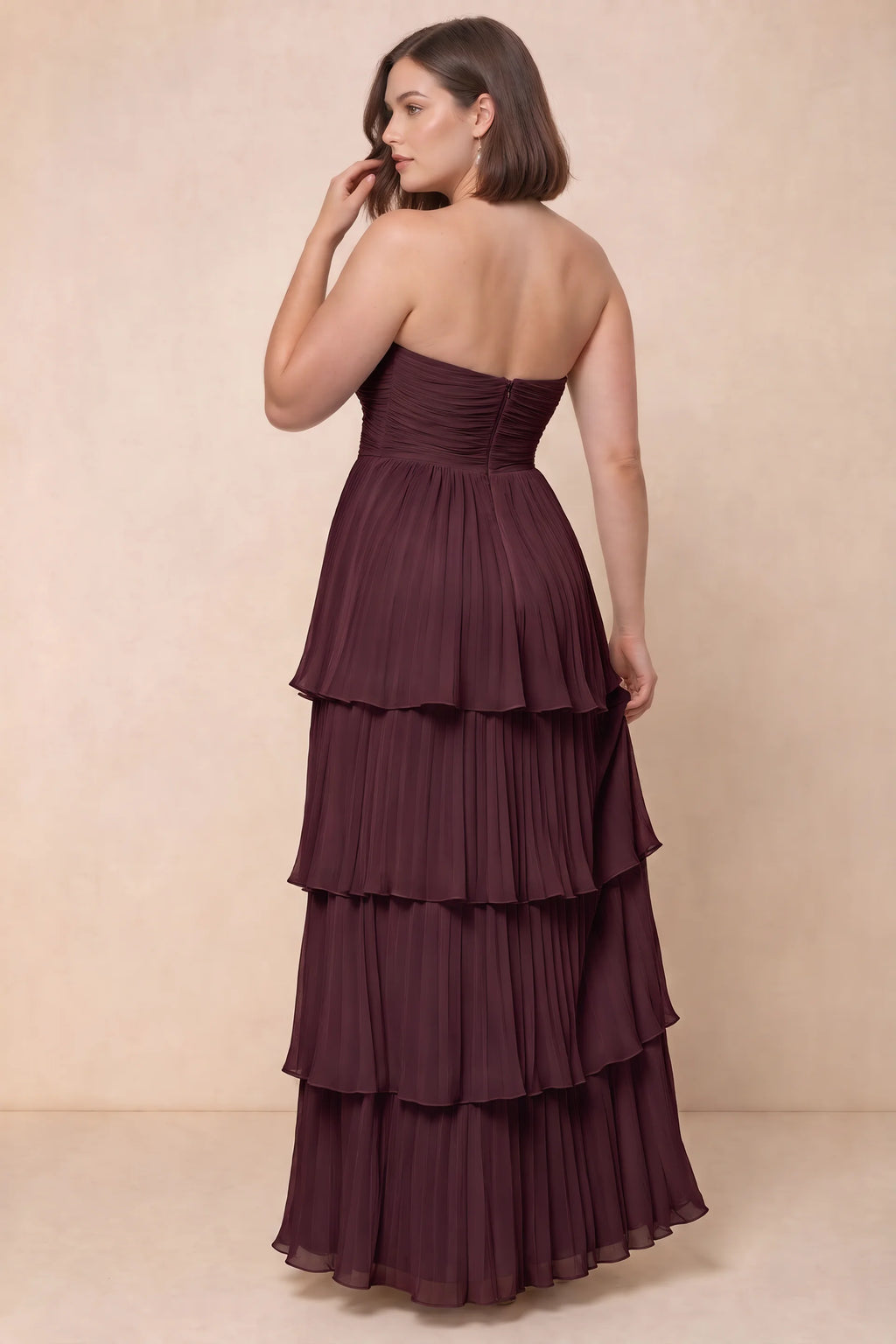 Rear view on a second model of Sonia burgundy tiered pleated maxi dress with a long flowing skirt