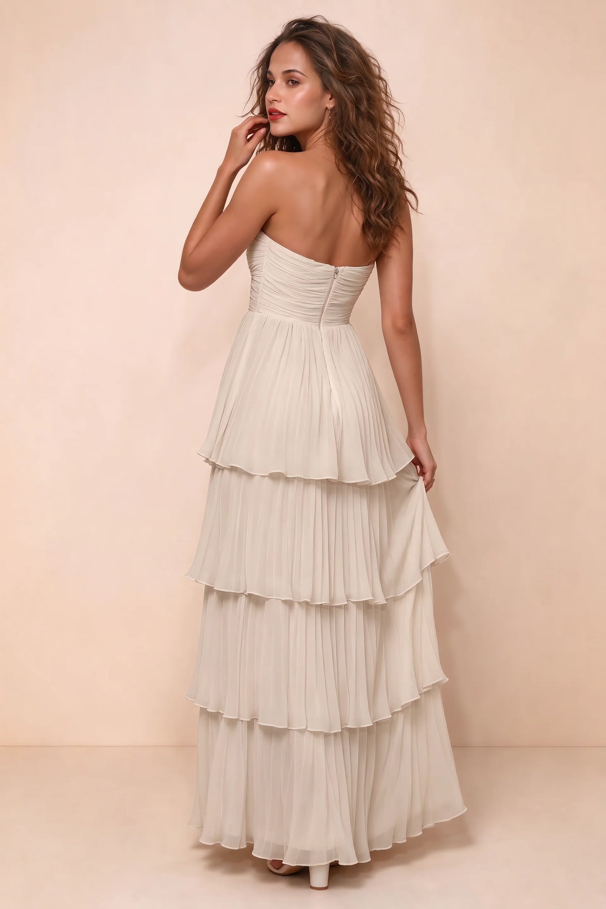 Rear studio view of Sonia cream tiered pleated maxi dress with a long flowing skirt