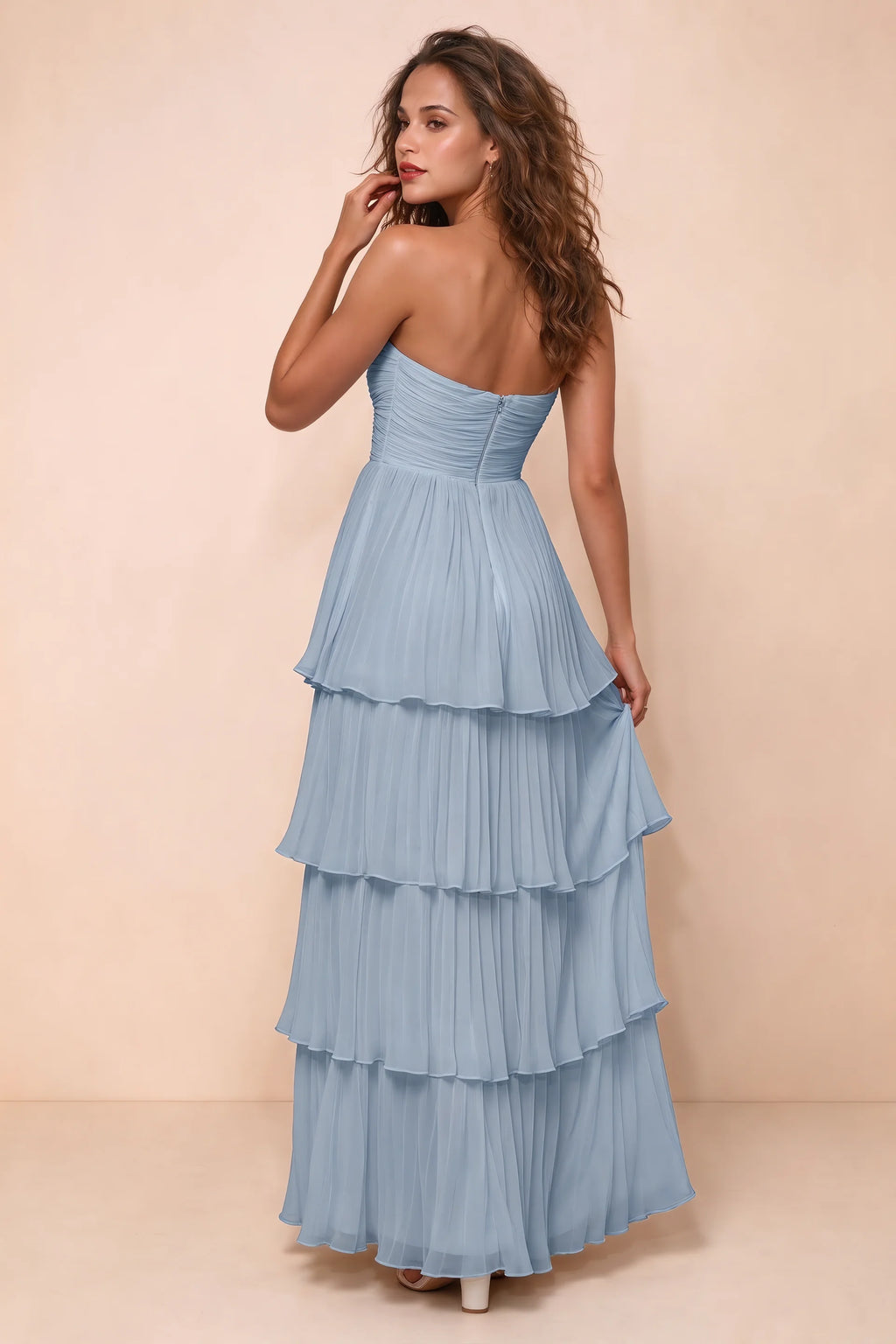 Rear studio view of Sonia dusty blue tiered pleated maxi dress with a long flowing skirt