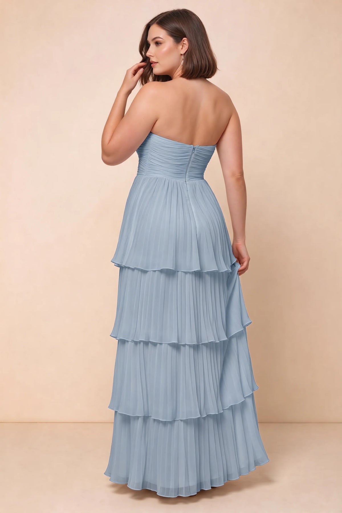 Rear view on a second model of Sonia dusty blue tiered pleated maxi dress with a long flowing skirt