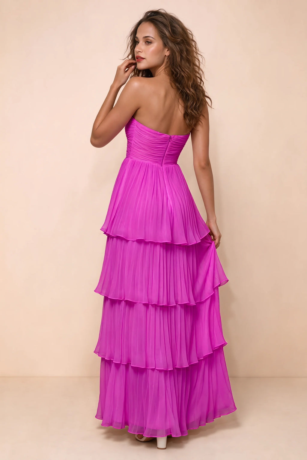 Rear studio view of Sonia fuchsia tiered pleated maxi dress with a long flowing skirt