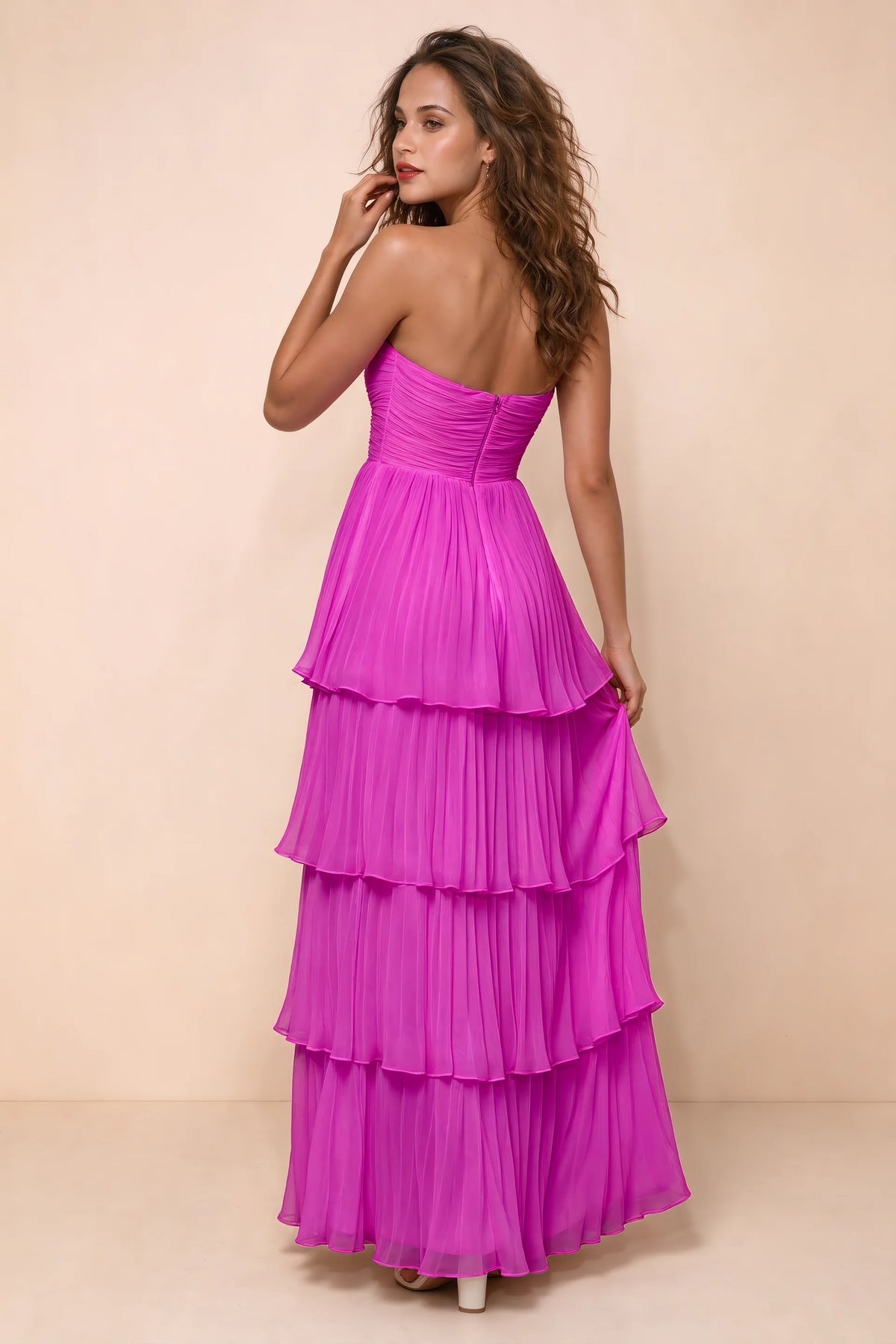 Rear studio view of Sonia fuchsia tiered pleated maxi dress with a long flowing skirt