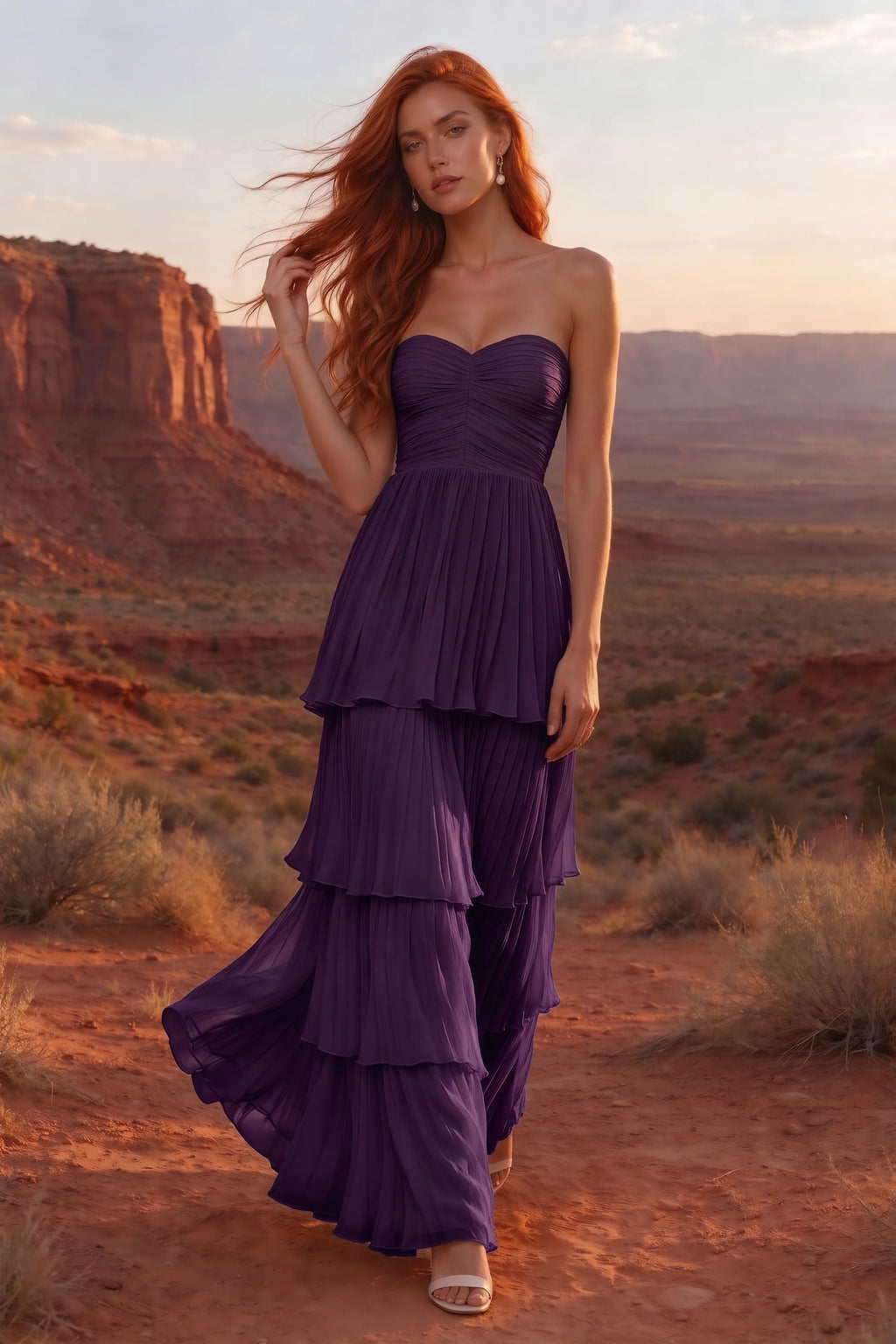 Outdoor front view in a desert canyon at sunset of Sonia grape tiered pleated maxi dress with a long flowing skirt