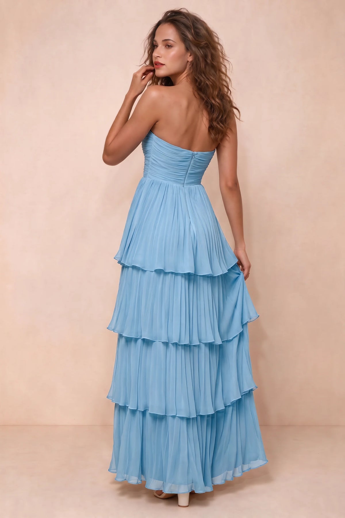 Rear studio view of Sonia haze blue tiered pleated maxi dress with a long flowing skirt