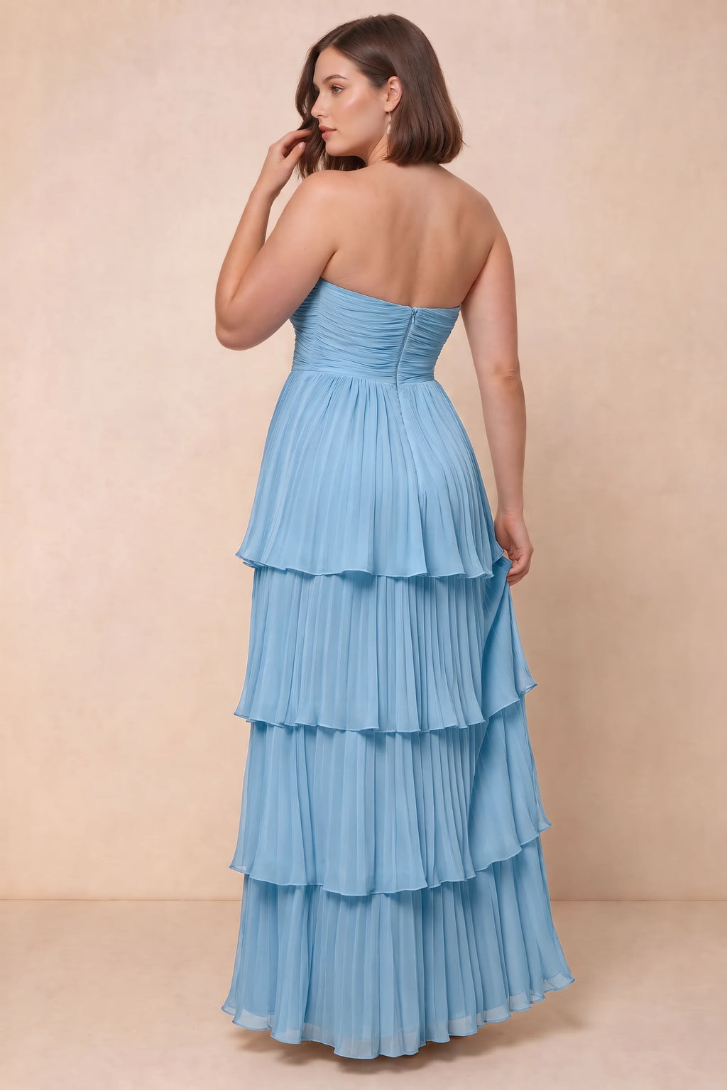 Rear view on a second model of Sonia haze blue tiered pleated maxi dress with a long flowing skirt
